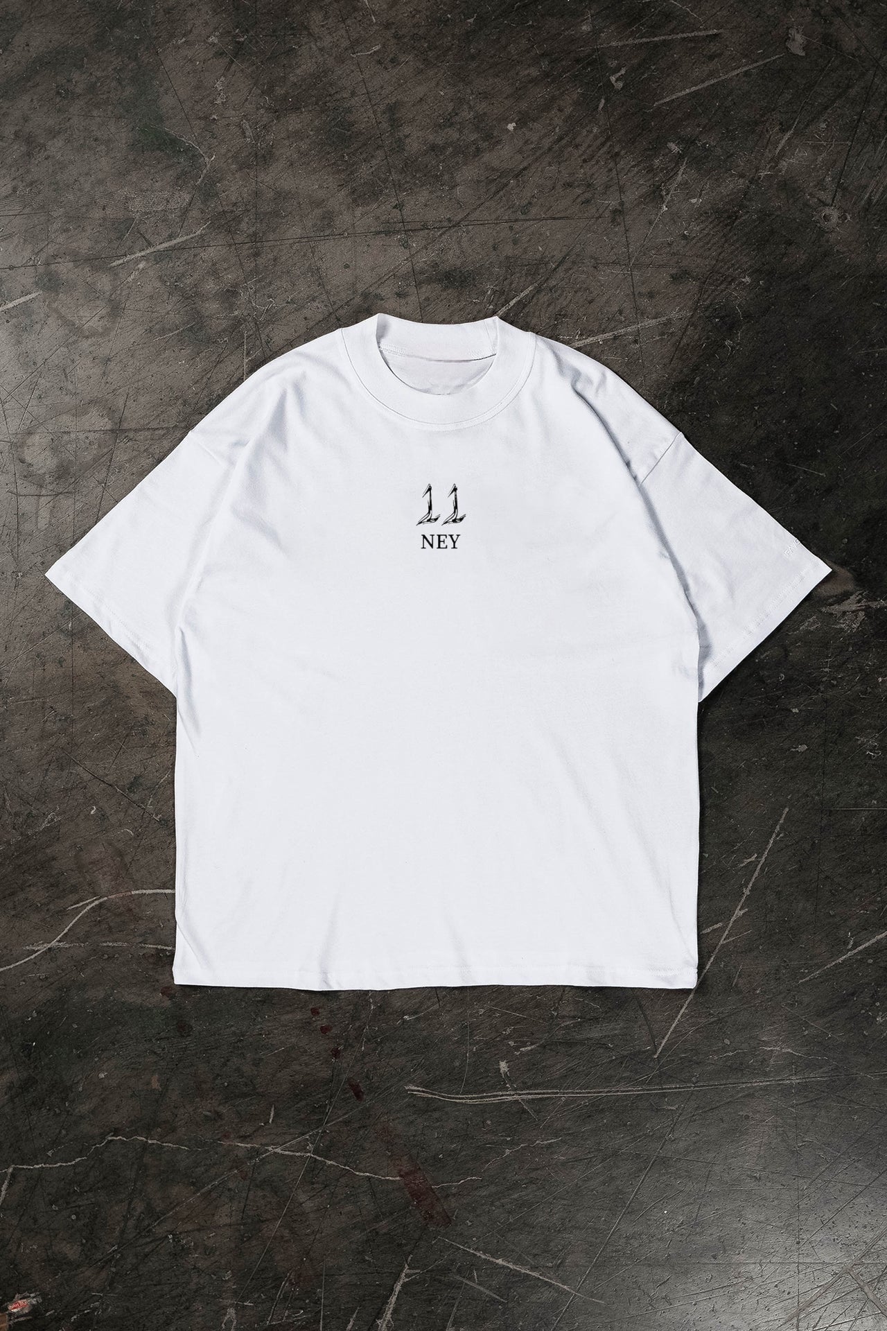 White t-shirt with black text on a dark textured surface